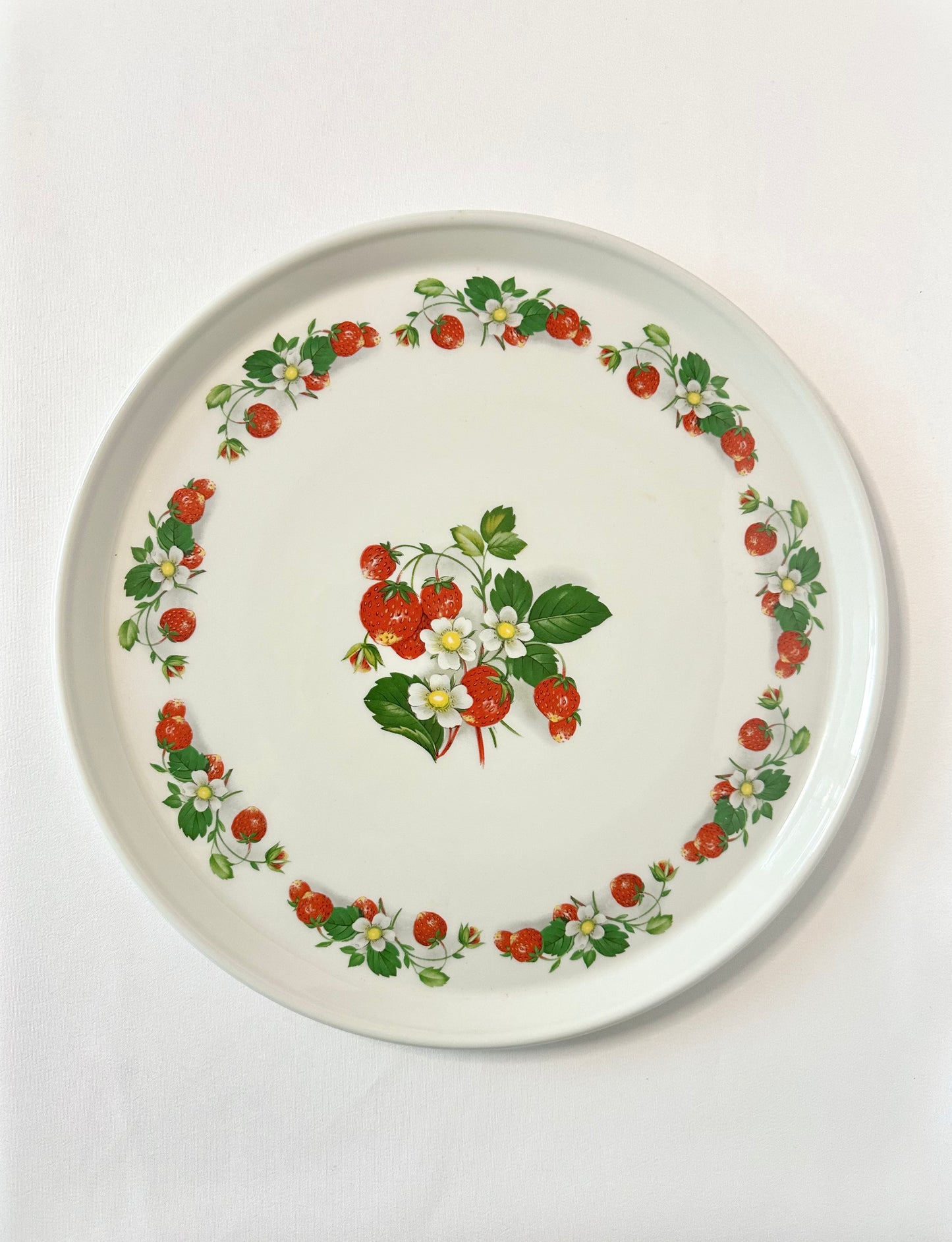 Vintage round ceramic serving platter featuring strawberries and white flowers.