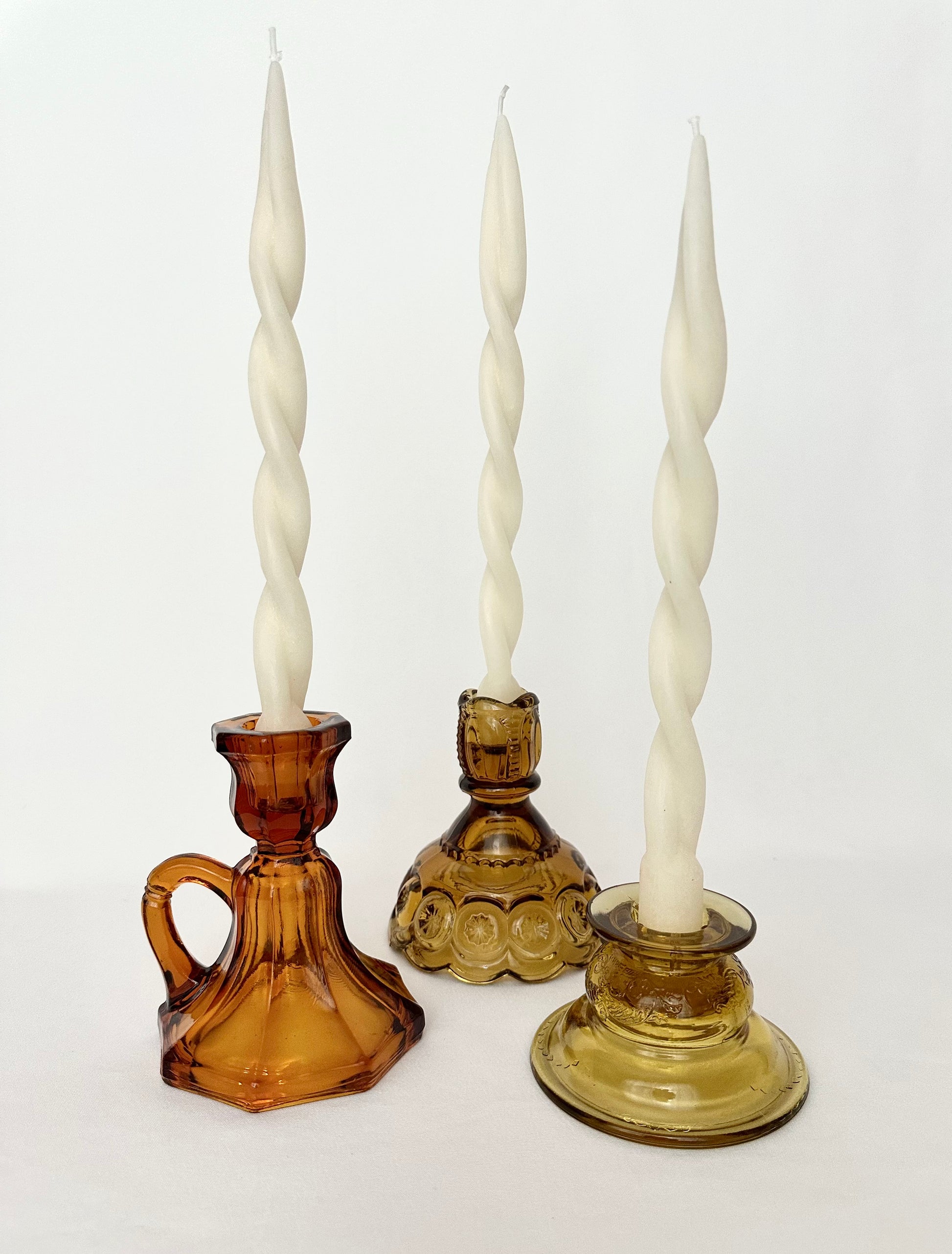 Mismatched, mixed set of three vintage amber glass candlestick holders.