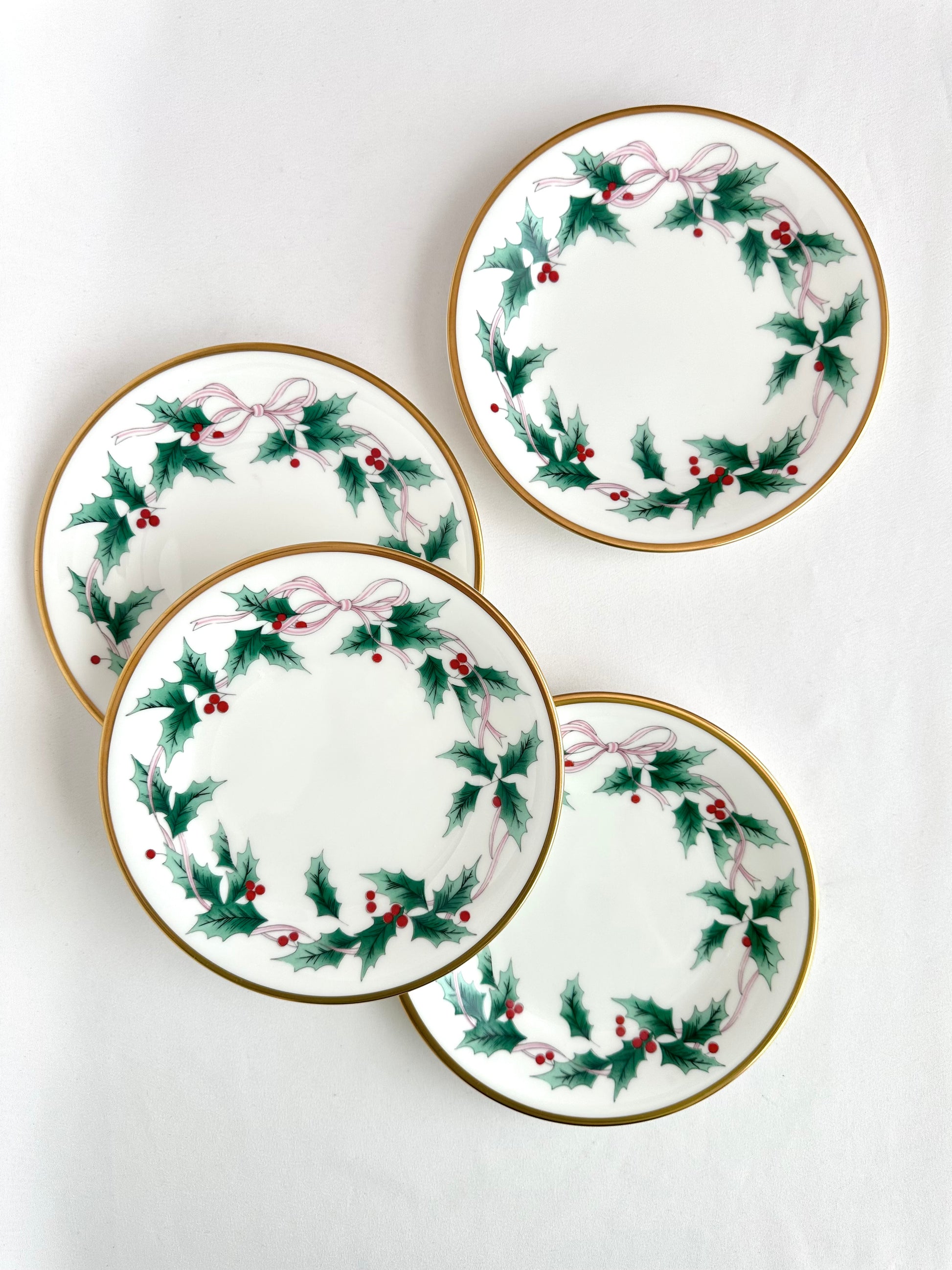 Vintage holiday themed small plates set of four decorated with holly leaves and pink ribbon by Mikasa.