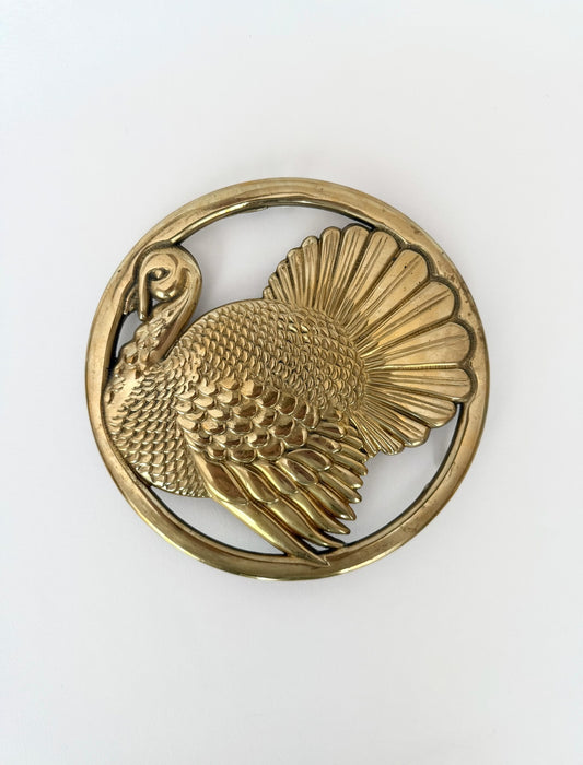 Vintage heavy brass turkey embossed round table trivet with rubber capped feet.