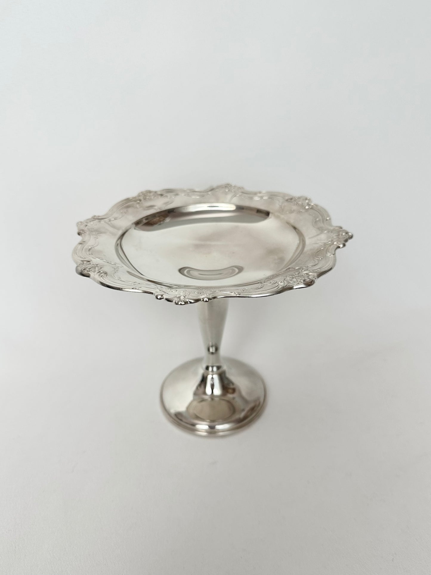 Vintage silverplate pedestal dish with scalloped embossed rim.