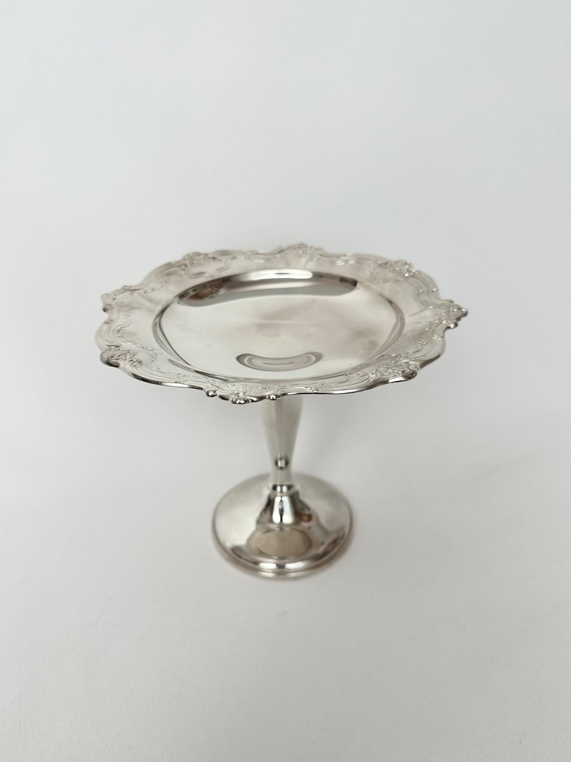 Vintage silverplate pedestal dish with scalloped embossed rim.