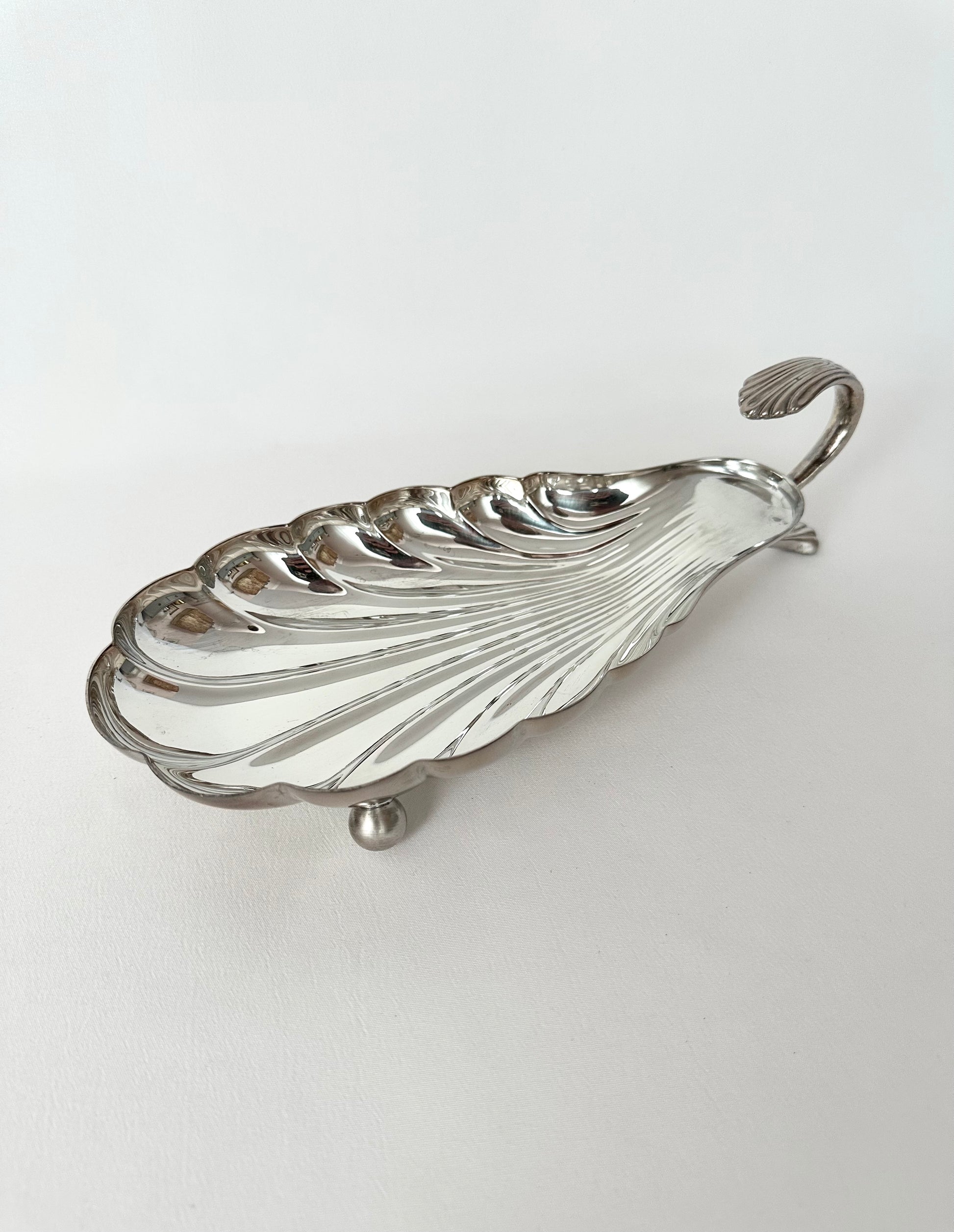 Vintage elongated seashell shaped footed serving dish with handle.