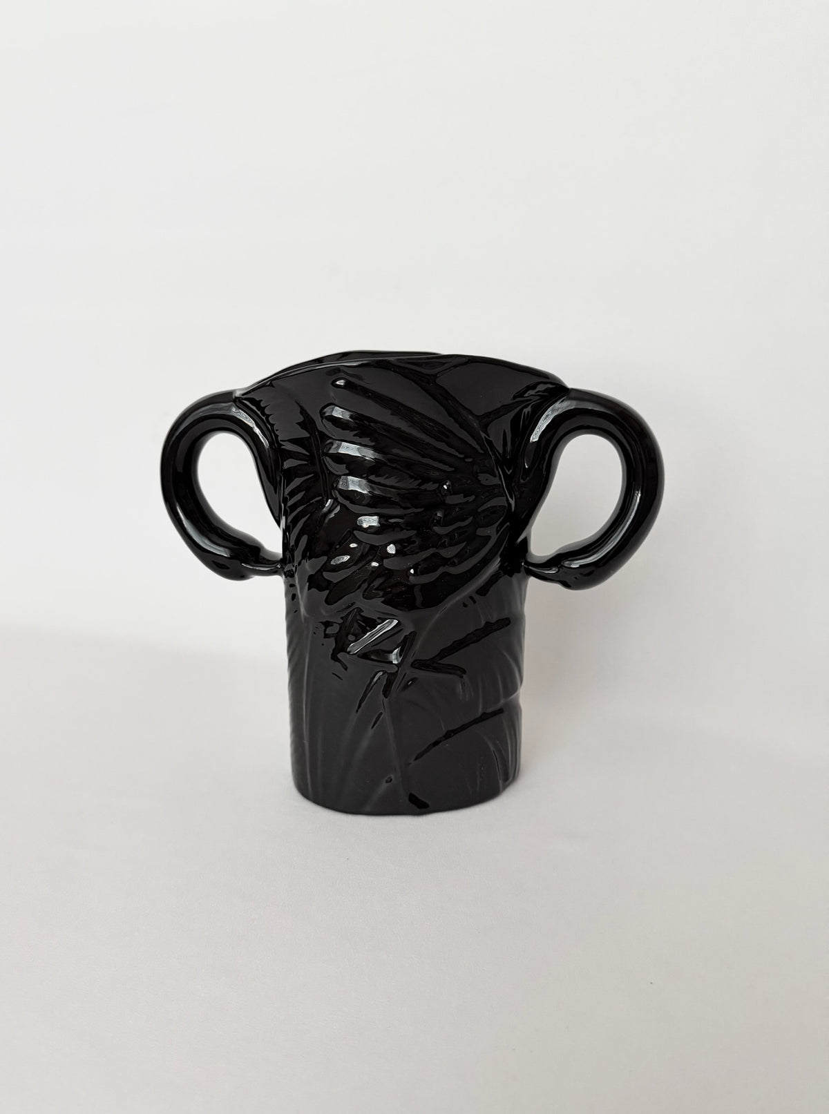 Vintage black glazed art deco style ceramic vase with a pair of flamingoes that form the handles.