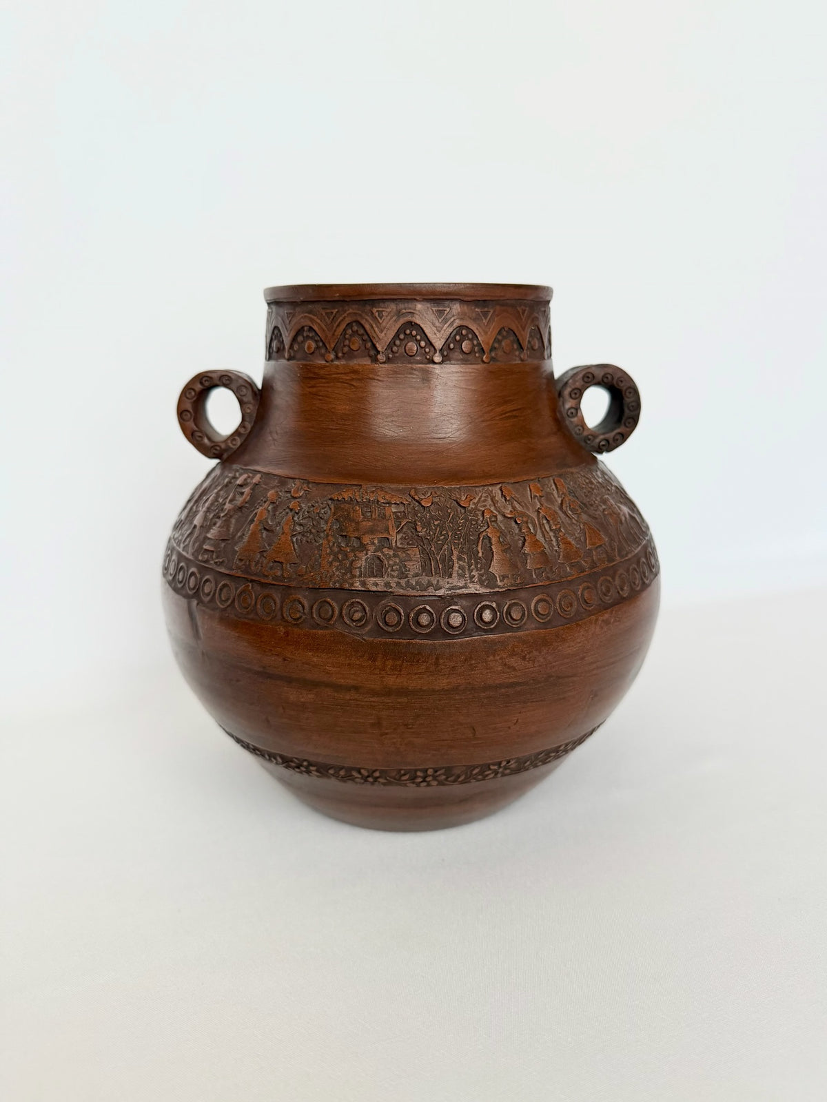 Vintage Greek pottery urn with mythological and geometric friezes around the perimeter.