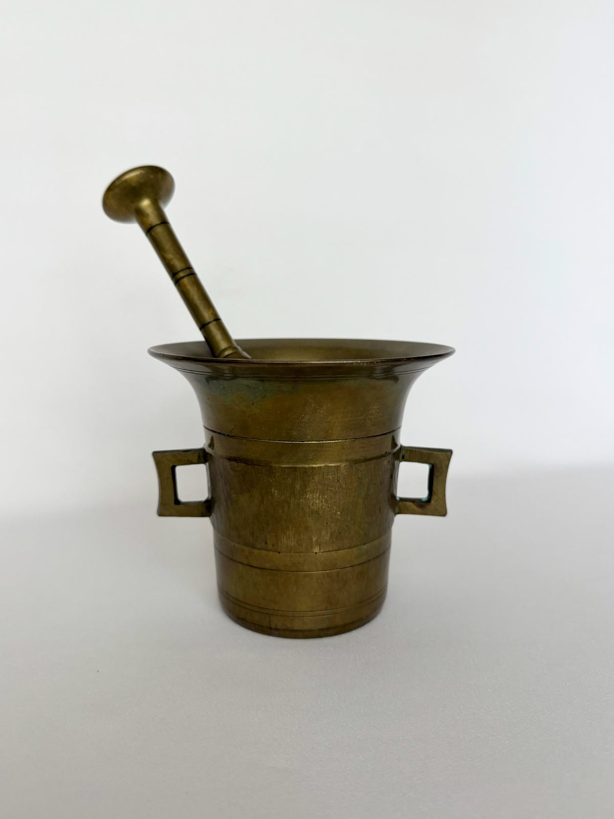 Antique European style heavy brass mortar and pestle decorative object.