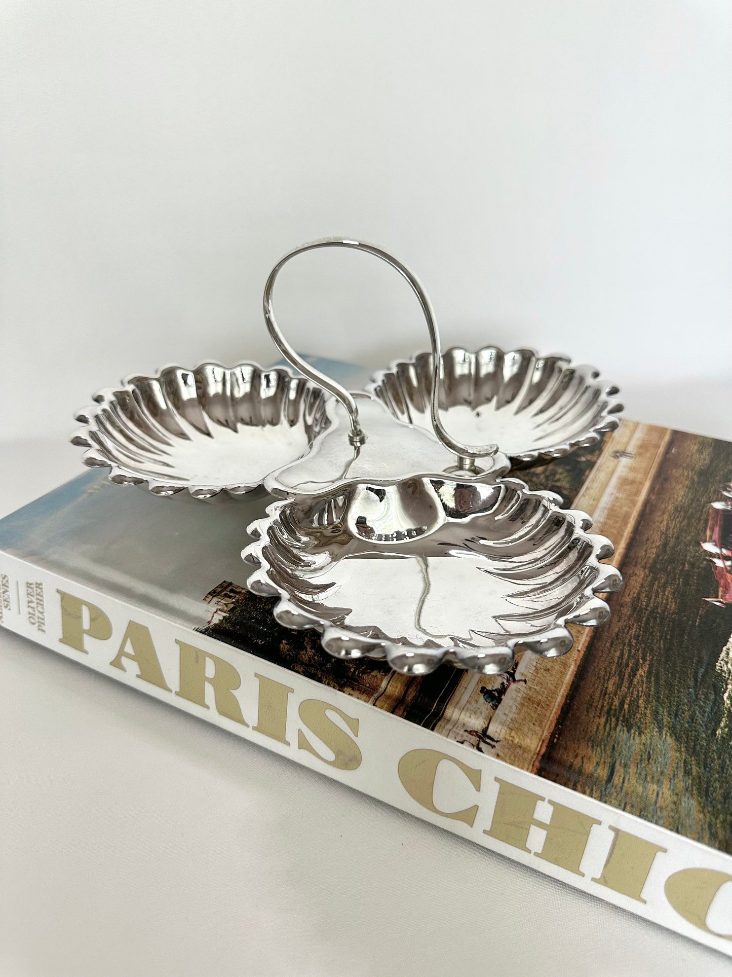 Vintage silverplate three part shell server with central handle.