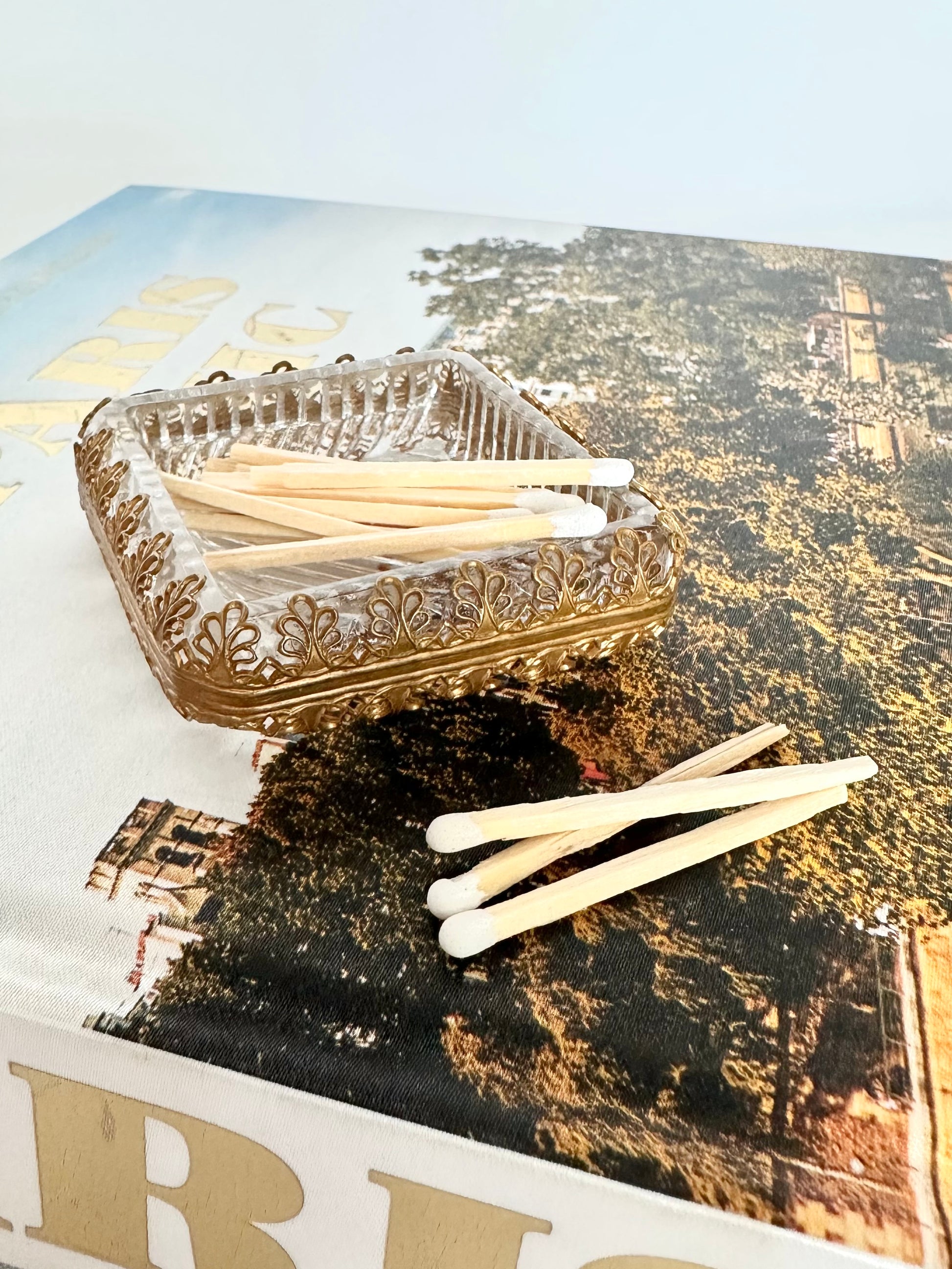 vintage gold filigree and cut glass small square dish paired with white tipped matchsticks
