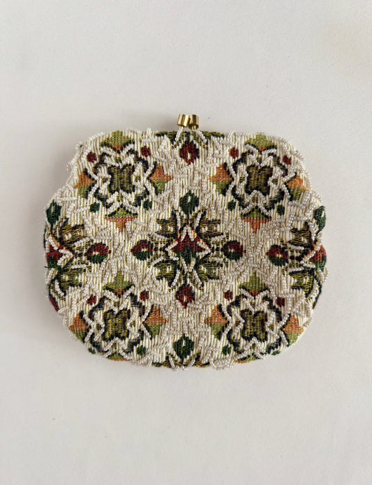 A vintage beaded clutch purse with an intricate floral pattern in green, red, and orange on a cream background, featuring a gold tones chain handle small gold-tone metal clasp at the top, 