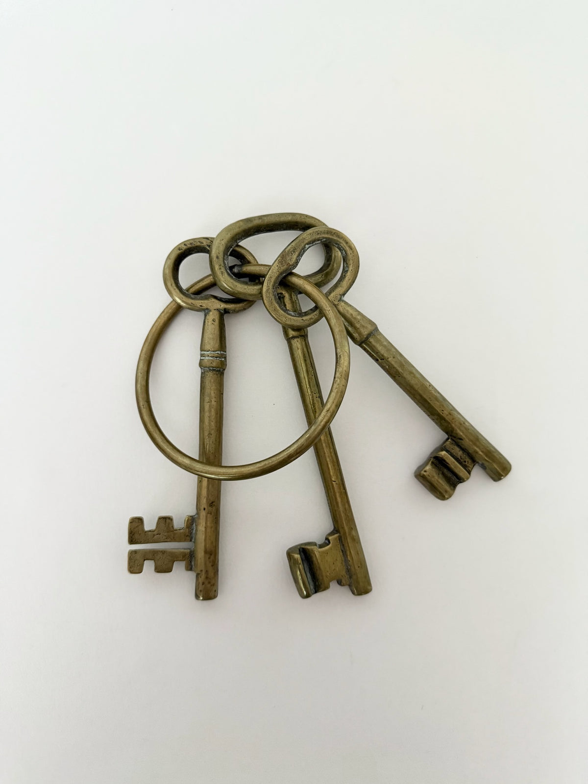 Vintage heavy brass skeleton keys on a large ring for decorative use.
