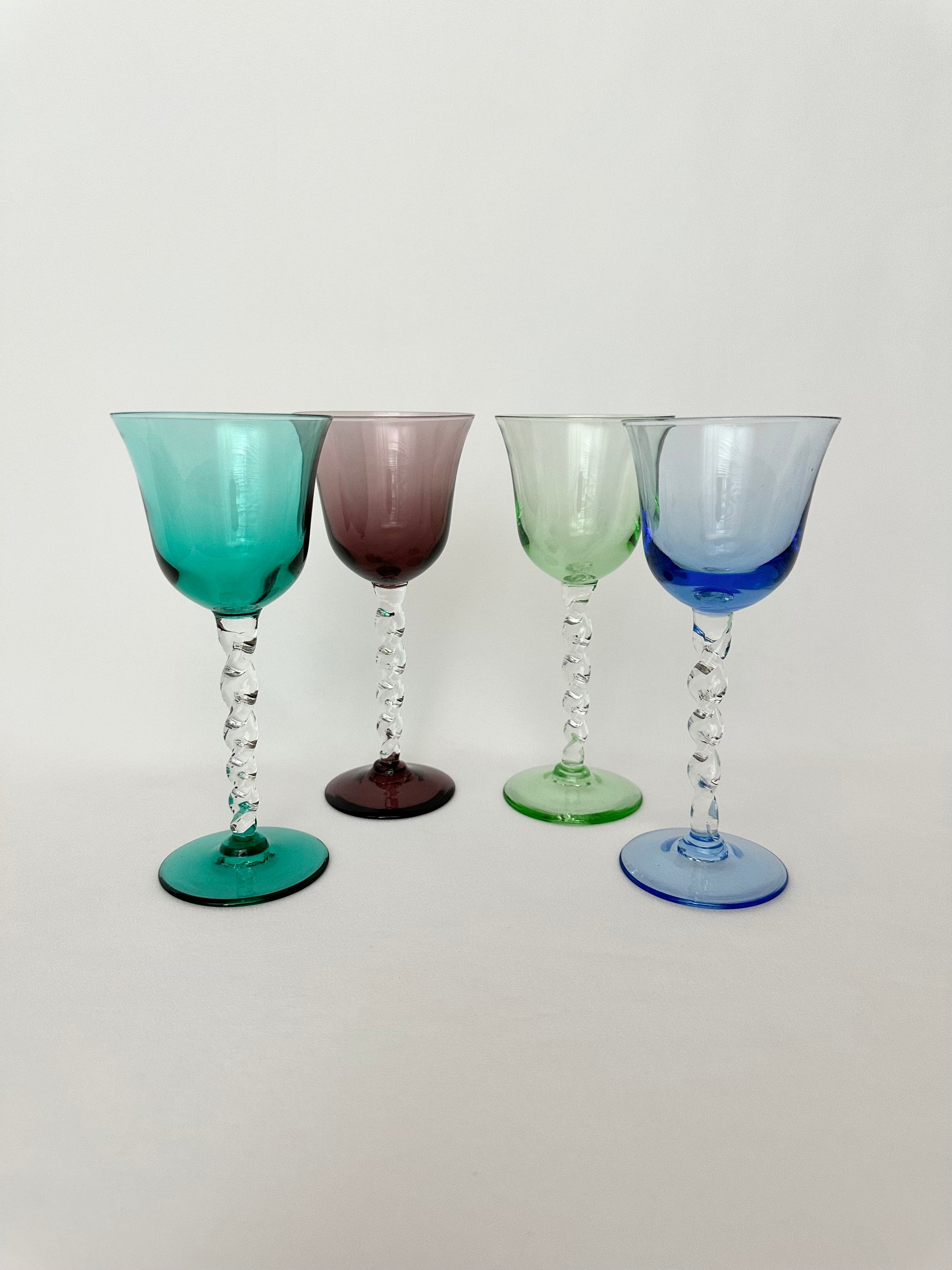 Mixed set of four jewel toned twisted stem cordials.