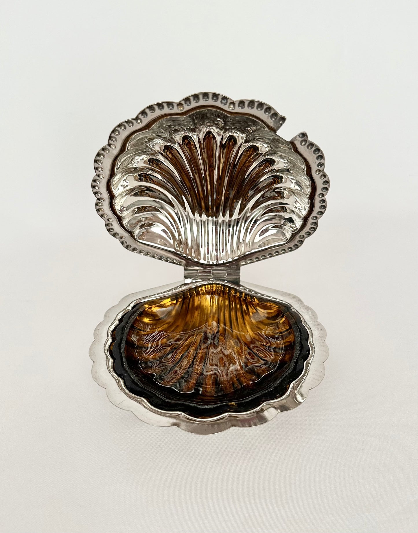 Silver plate lidded clamshell butter dish with amber glass liner.