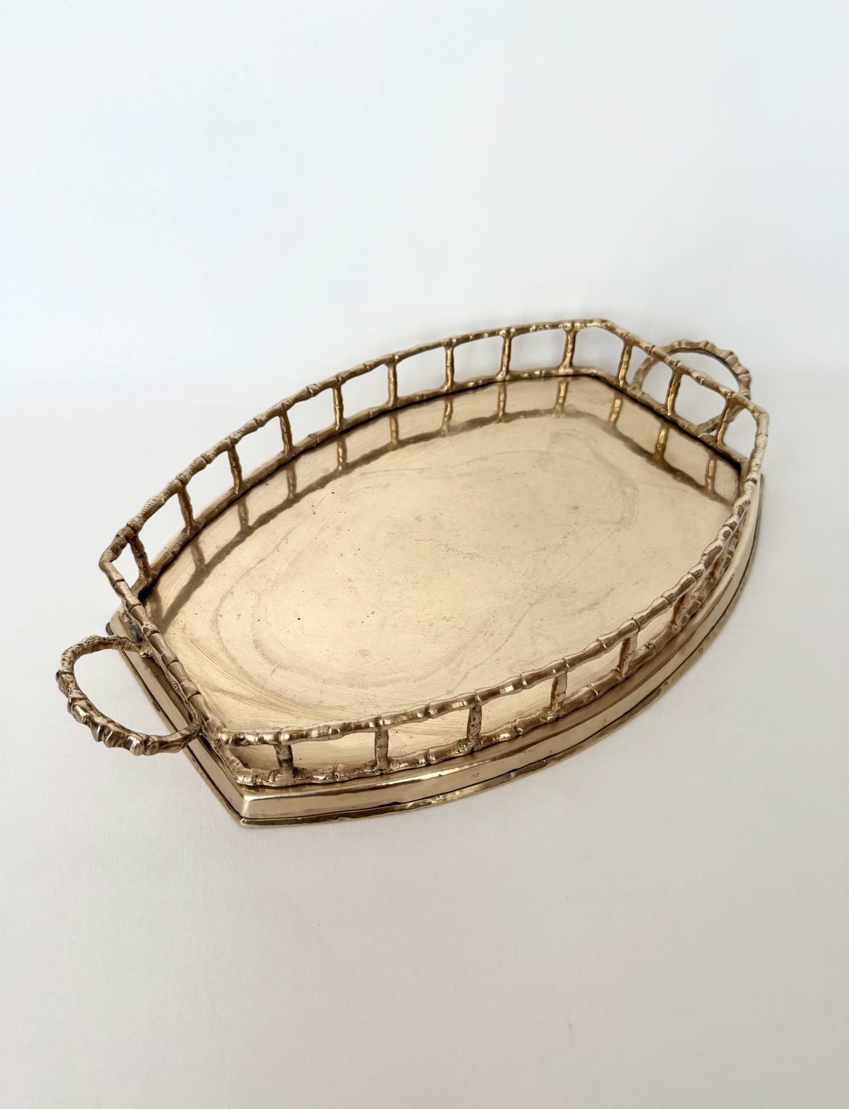 Vintage brass bamboo rail tray in an oval shape with handles.