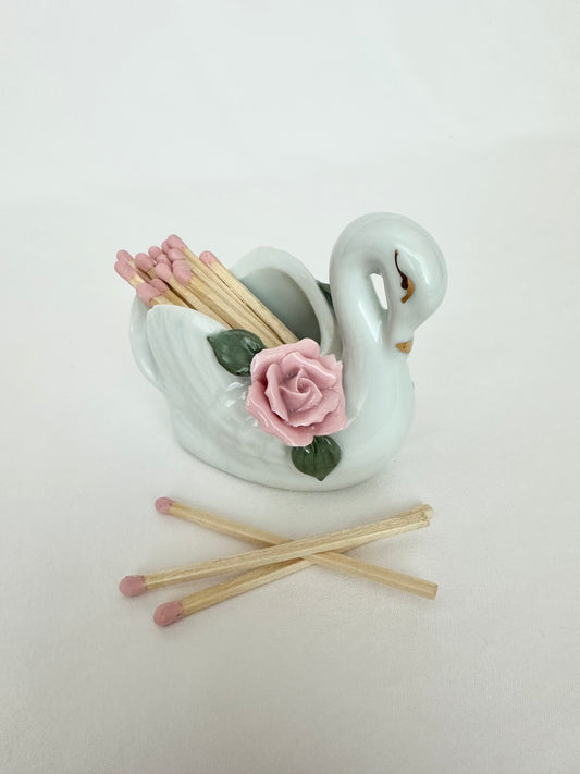 Vintage porcelain swan match holder with light pink matchstick bundle