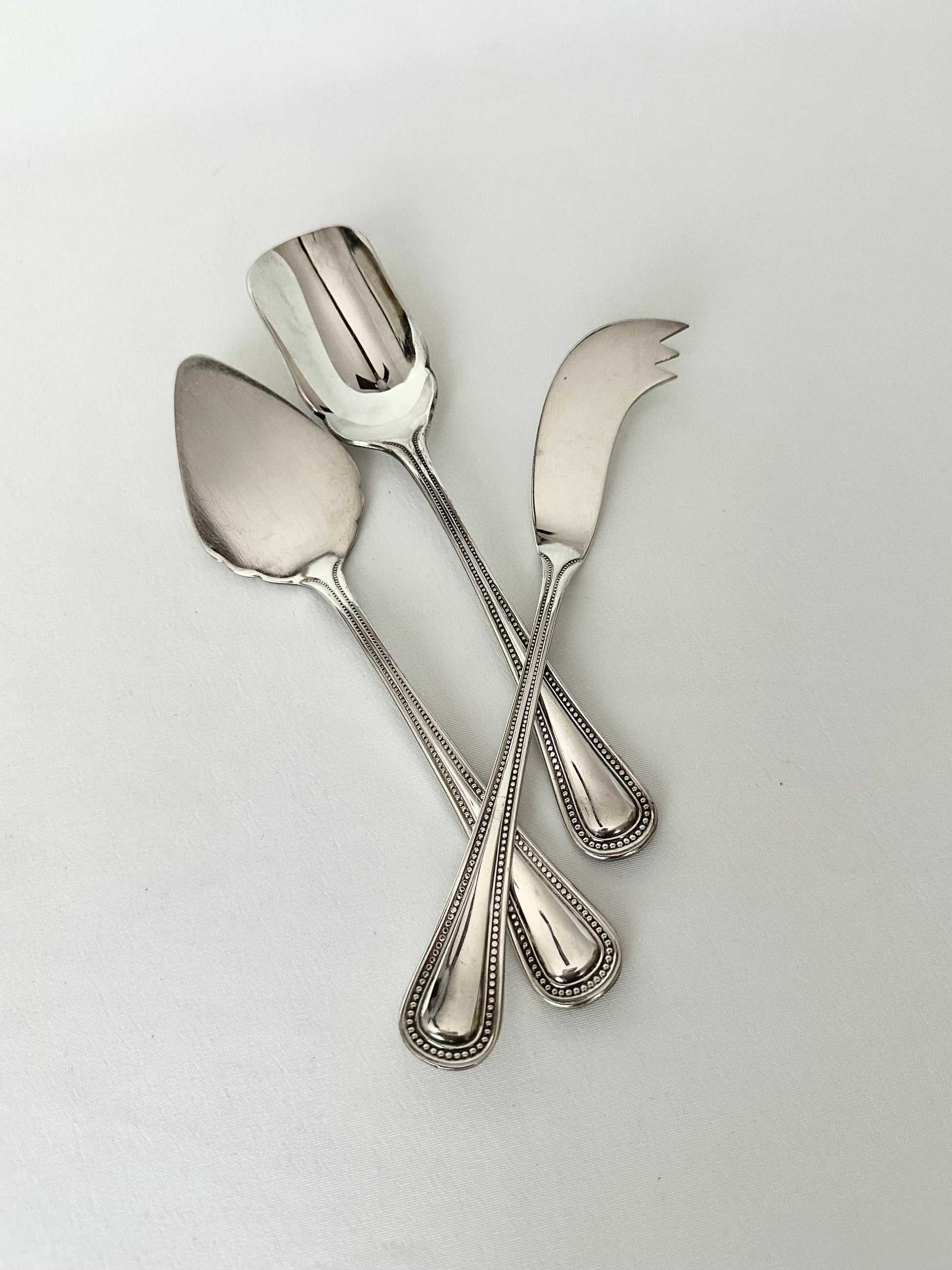 Vintage set of three silverplate cheese serving utensils.