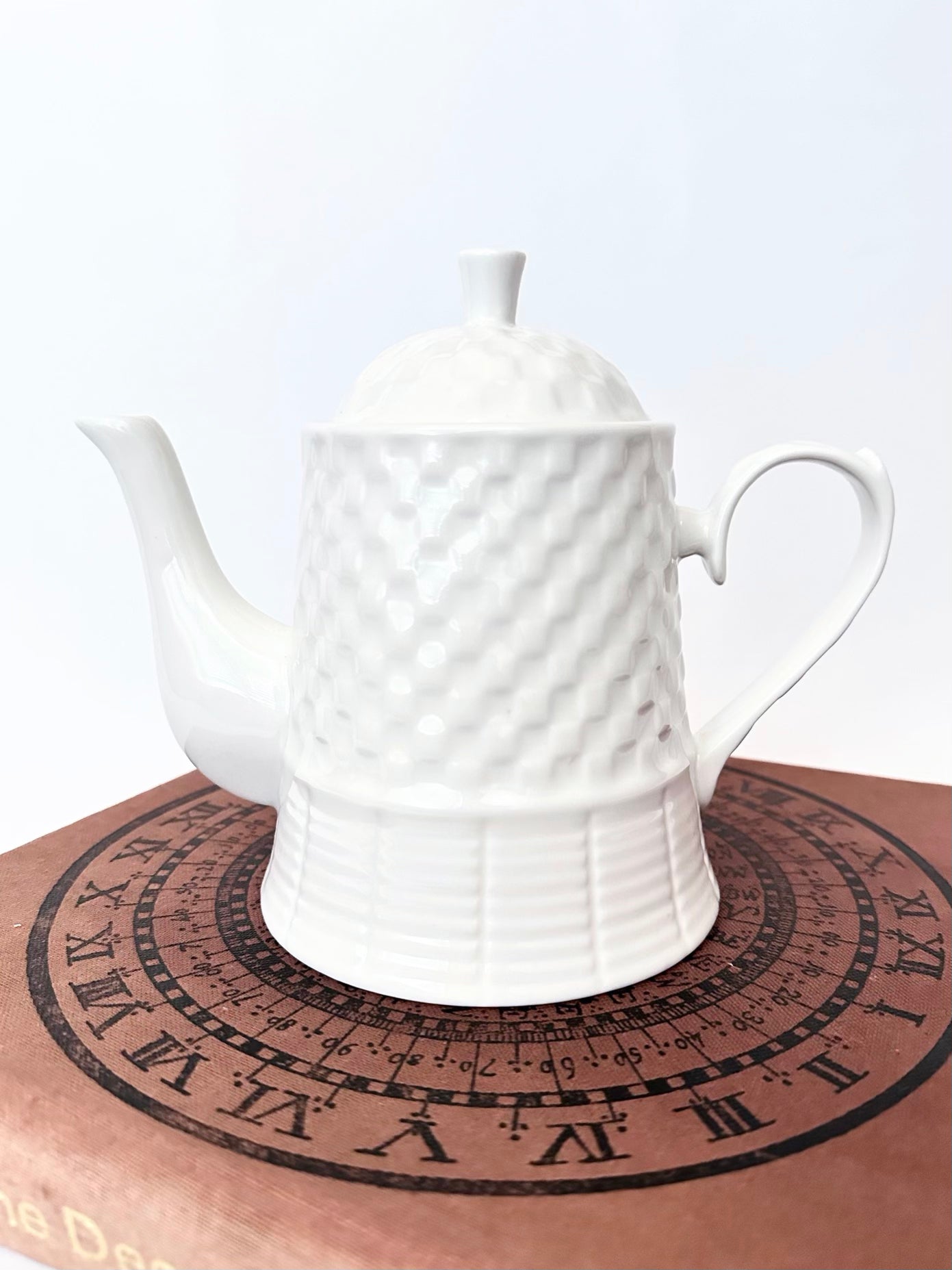 white ceramic tea pot with basket weave pattern.