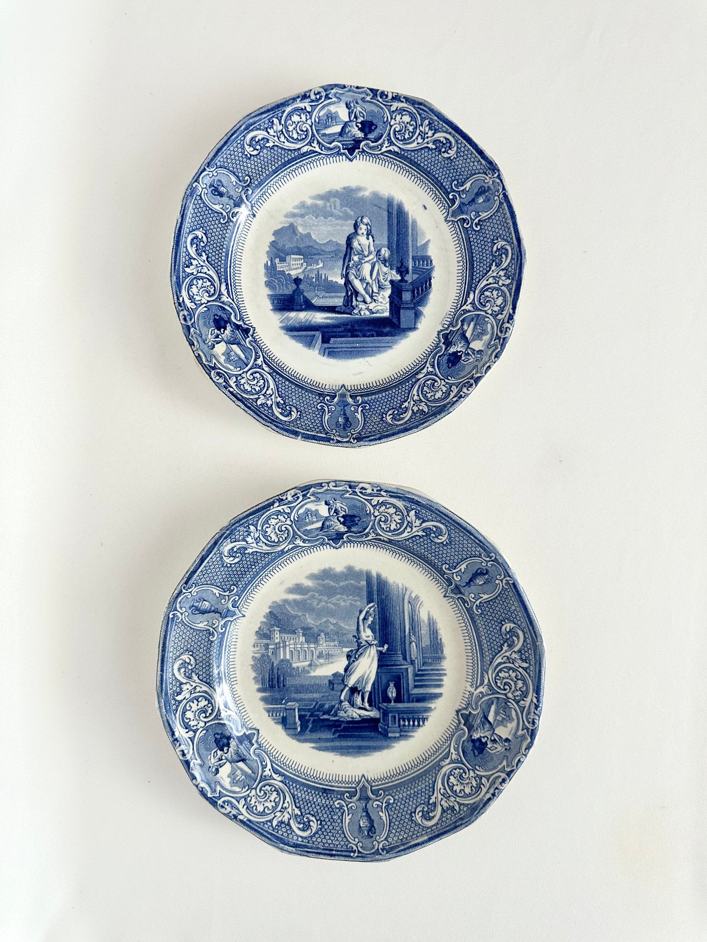 antique blue and white transferware decorative plates with scenery including buildings and people