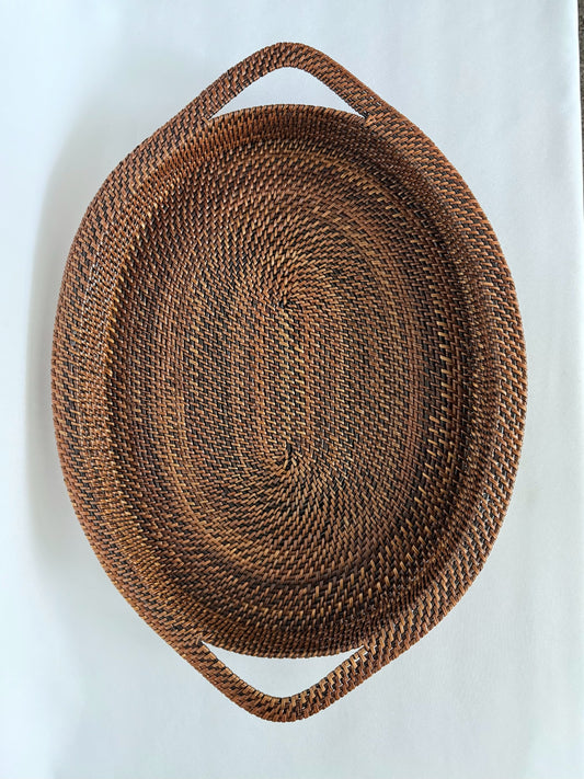 large brown woven wicker oval rimmed tray with handles