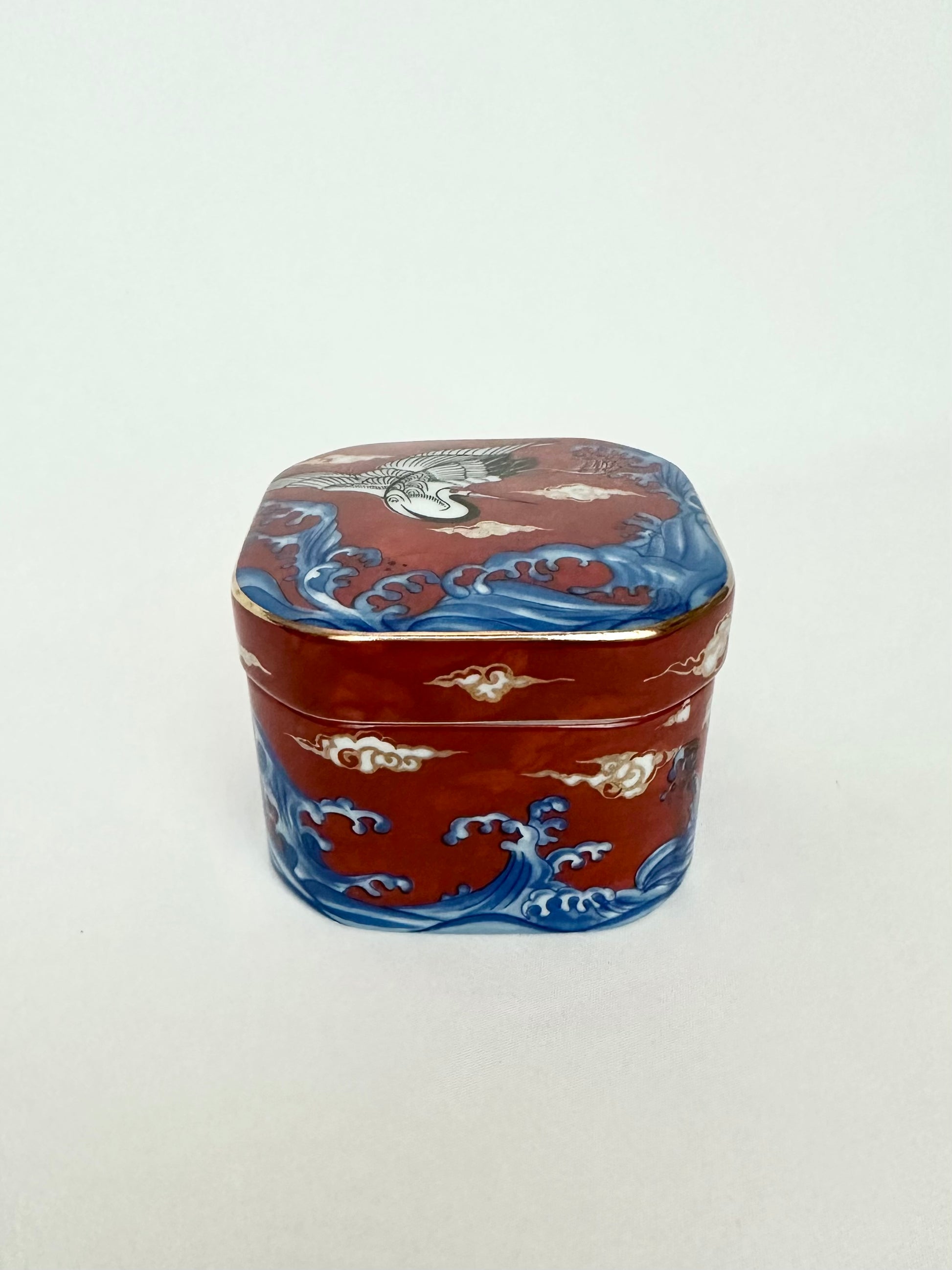 Vintage small square porcelain lidded chinoiserie trinket box with orange blue and white pattern.